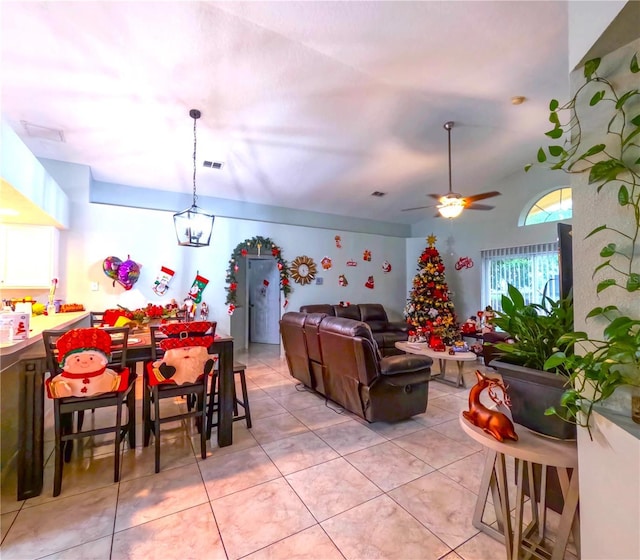 living room with light tile patterned floors, ceiling fan, and lofted ceiling