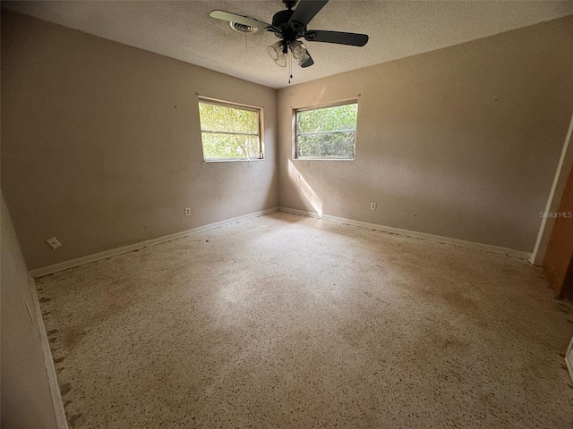 unfurnished room with ceiling fan and a textured ceiling