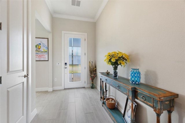 doorway featuring light wood-type flooring and crown molding