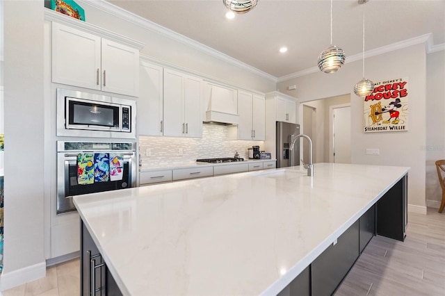 kitchen with a large island with sink, white cabinets, stainless steel appliances, and custom range hood