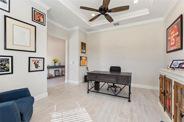 office space with a raised ceiling, crown molding, and ceiling fan