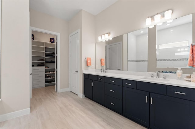 bathroom with hardwood / wood-style flooring, vanity, and a shower