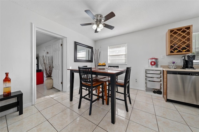 dining room with ceiling fan, light tile patterned floors, a textured ceiling, and bar