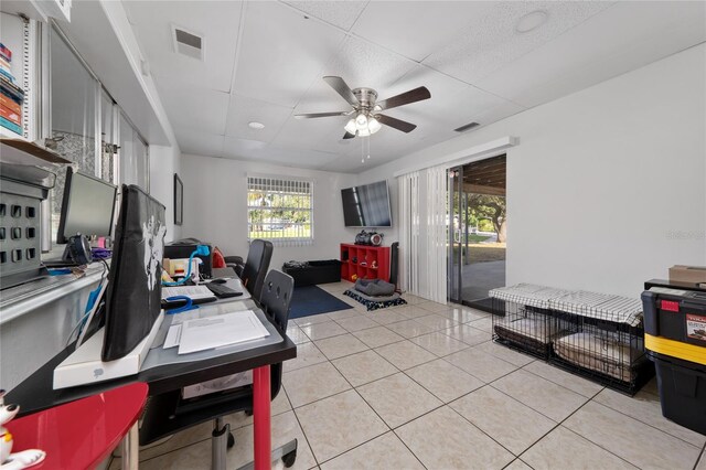 office area with light tile patterned floors, a paneled ceiling, and ceiling fan