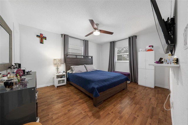 bedroom featuring a textured ceiling, dark hardwood / wood-style floors, and ceiling fan