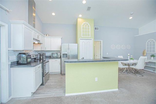 kitchen featuring a center island, light colored carpet, white cabinetry, and appliances with stainless steel finishes