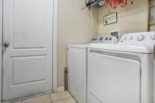 laundry room featuring washer and clothes dryer and light tile patterned flooring