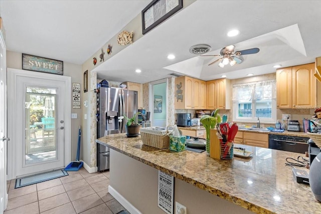 kitchen with light stone countertops, stainless steel fridge, a wealth of natural light, and light brown cabinetry