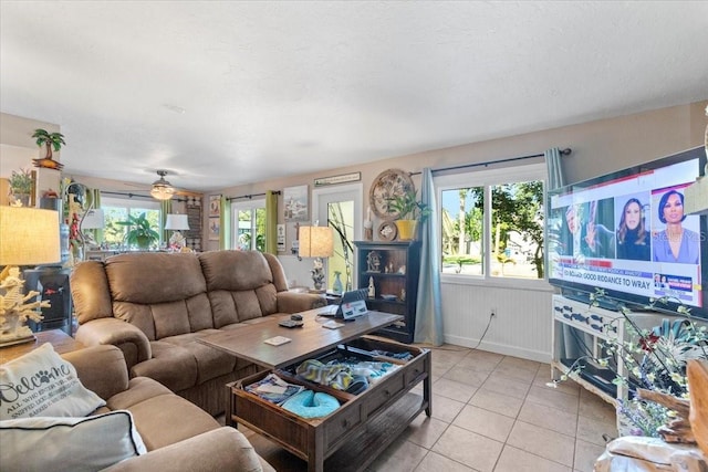 living room featuring ceiling fan, light tile patterned floors, and a healthy amount of sunlight