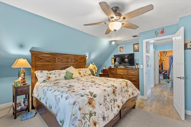 bedroom with ceiling fan, lofted ceiling, a walk in closet, a closet, and light wood-type flooring