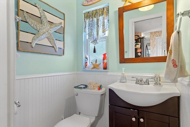 bathroom featuring a wealth of natural light, vanity, and toilet