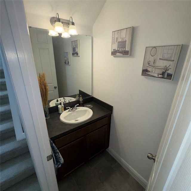 bathroom featuring tile patterned floors, vanity, and vaulted ceiling