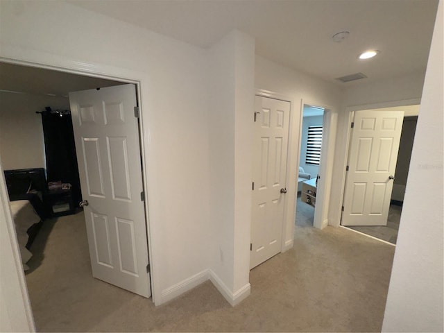 hallway featuring light colored carpet