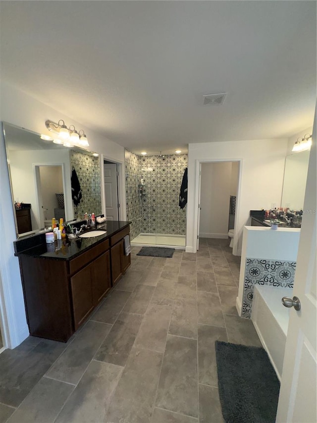 bathroom with tile patterned floors, vanity, and shower with separate bathtub