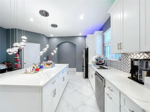 kitchen featuring white cabinets, decorative light fixtures, a center island, and appliances with stainless steel finishes