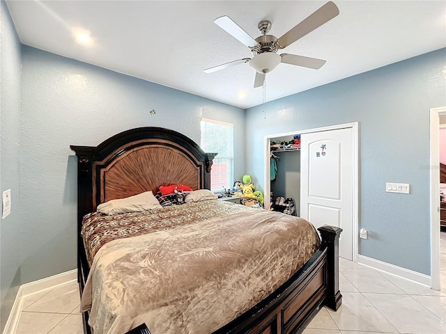 tiled bedroom featuring ceiling fan and a closet