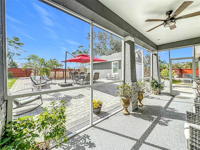 unfurnished sunroom featuring ceiling fan