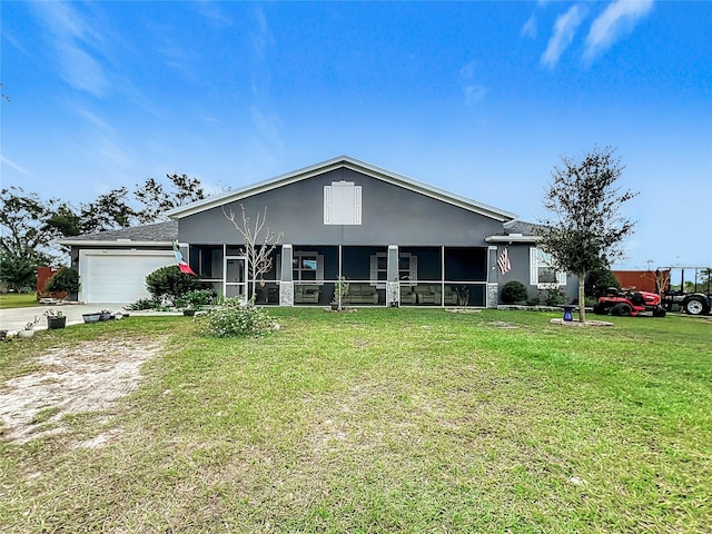 view of front of house with a sunroom, a front lawn, and a garage