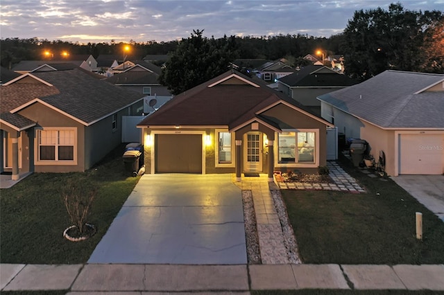 view of front of property featuring a garage and a lawn