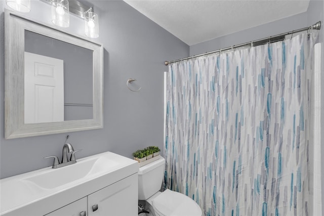 bathroom with a shower with curtain, vanity, a textured ceiling, and toilet