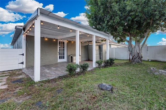 rear view of house featuring a patio and a lawn