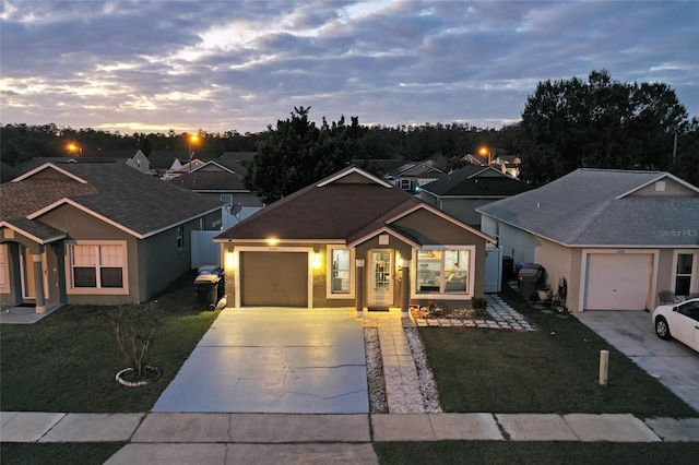 single story home featuring a garage and a yard