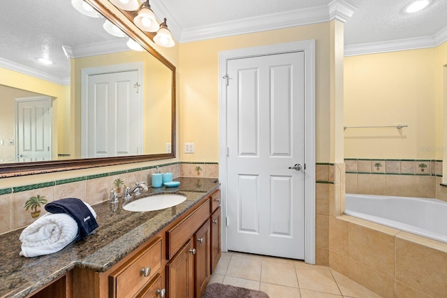 bathroom with tile patterned flooring, tiled bath, a textured ceiling, vanity, and ornamental molding