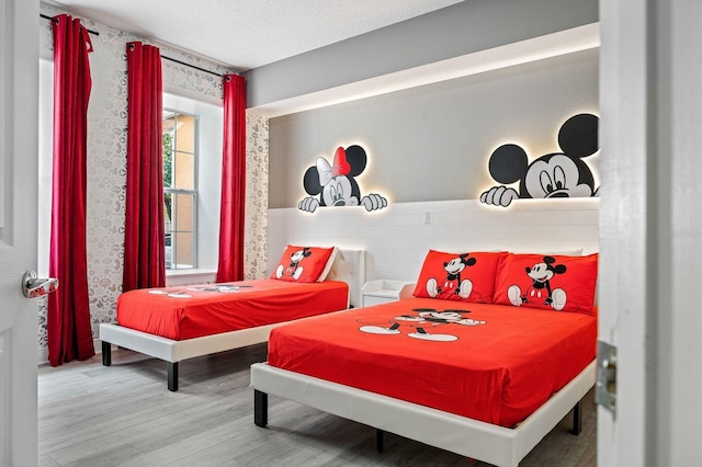 bedroom with hardwood / wood-style floors and a textured ceiling