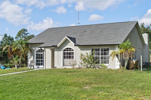 rear view of house with central air condition unit and a yard