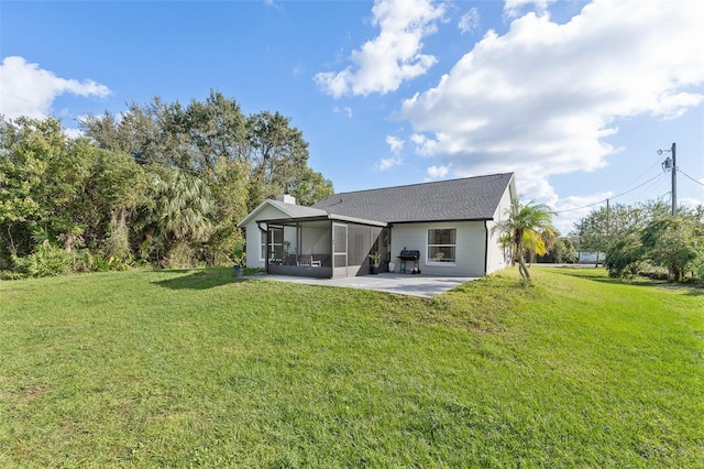 rear view of house featuring a lawn, a patio area, and a sunroom