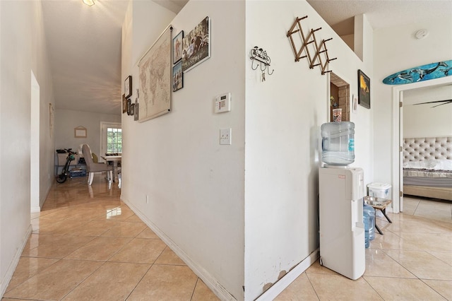 hall with light tile patterned flooring and a textured ceiling