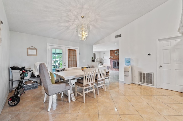 dining room featuring lofted ceiling, light tile patterned floors, and french doors