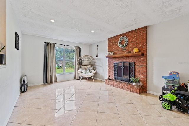 living room with a fireplace, light tile patterned floors, and a textured ceiling