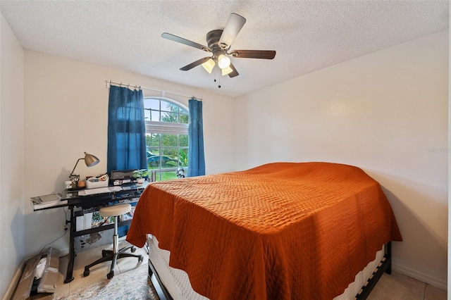 tiled bedroom featuring ceiling fan and a textured ceiling