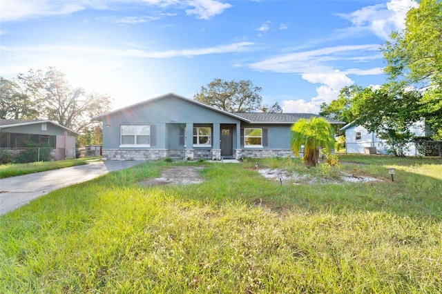 2108 Lemon St, Haines City, FL 33844 - view of front of home with stone siding, stucco siding, fence, and driveway