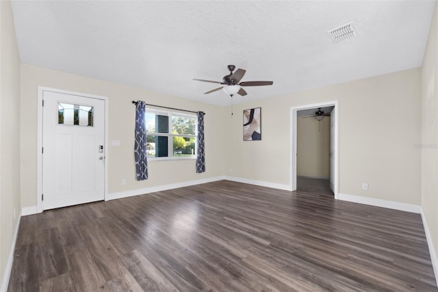 2108 Lemon St, Haines City, FL 33844 - unfurnished living room featuring a ceiling fan, dark wood-type flooring, baseboards, and a textured ceiling
