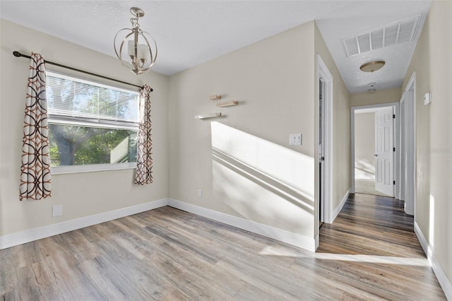 interior space featuring a chandelier, wood-type flooring, and a textured ceiling