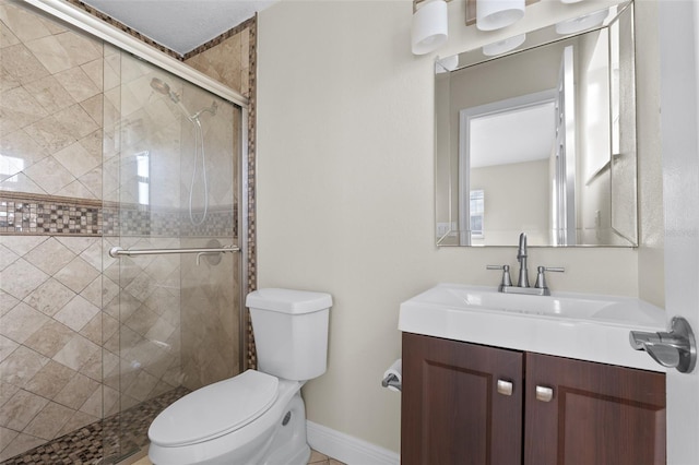 bathroom featuring vanity, a shower with shower door, and toilet