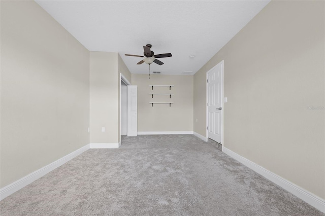 carpeted spare room with ceiling fan