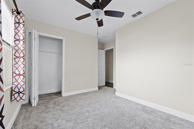 unfurnished bedroom featuring light carpet, a closet, and ceiling fan