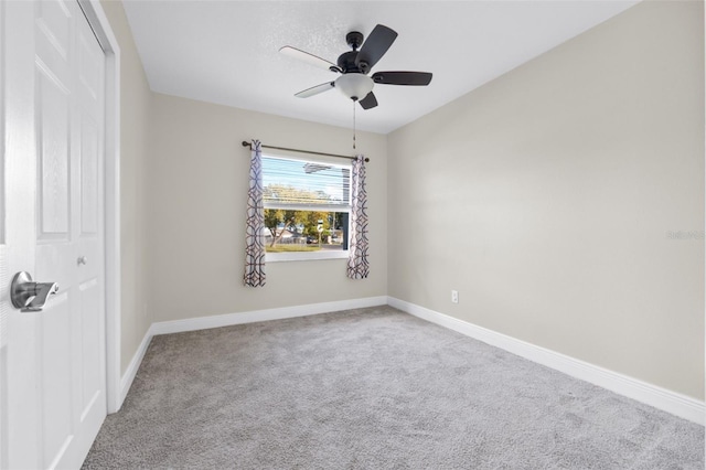 spare room featuring light carpet and ceiling fan