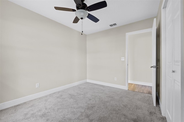 carpeted spare room featuring ceiling fan