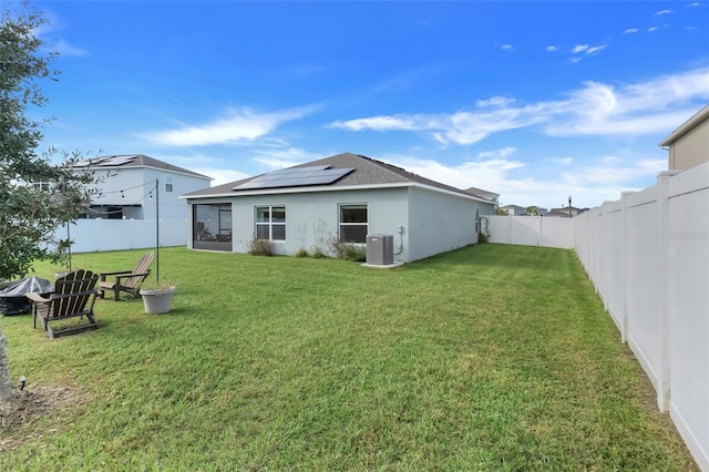 356 Citrine Loop, Kissimmee, FL 34758 - rear view of house featuring roof mounted solar panels, stucco siding, a fenced backyard, and a sunroom