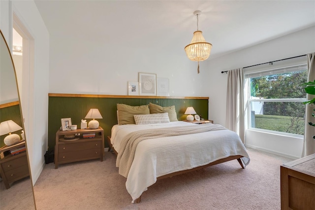 bedroom with light colored carpet and an inviting chandelier