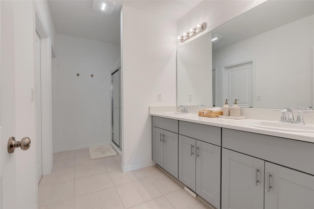 bathroom featuring tile patterned flooring, vanity, and a shower with door