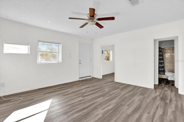 spare room featuring ceiling fan, light wood-type flooring, and a textured ceiling