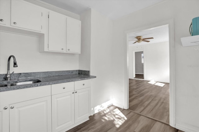 kitchen featuring hardwood / wood-style floors, ceiling fan, white cabinets, and sink