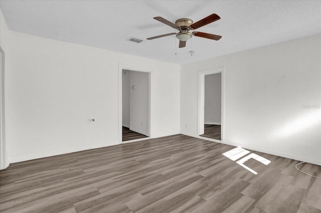 empty room featuring ceiling fan, light hardwood / wood-style floors, and a textured ceiling