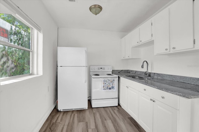 kitchen with sink, dark stone counters, white appliances, white cabinets, and light wood-type flooring