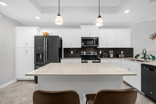 kitchen featuring sink, stainless steel appliances, white cabinetry, and hanging light fixtures